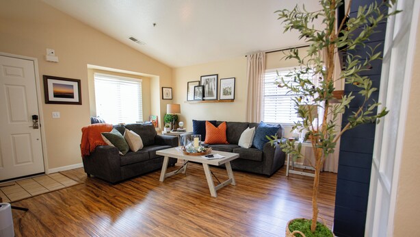 A living room with hardwood flooring, two dark-colored sofas with various cushions, a white coffee table, and a potted plant. - Mountain Retreat 4 Miles to Park Entrance Walk to Dining (Three Rivers)