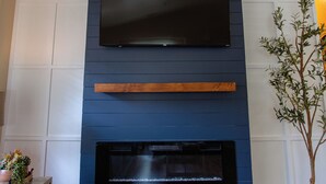 A modern living room with a flat-screen TV mounted on a dark blue wall above a fireplace. - Mountain Retreat 4 Miles to Park Entrance Walk to Dining (Three Rivers)