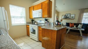 A kitchen with wooden cabinets, a stove, and a microwave. - Mountain Retreat 4 Miles to Park Entrance Walk to Dining (Three Rivers)