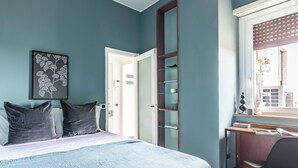A bedroom with a bed, a desk, and a chair. There is a door leading to another room. - [Vista Duomo] Trilocale vintage vicino a Centrale (Milan)