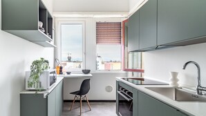 A compact kitchen with a window, built-in cabinets, and a small dining area. - [Vista Duomo] Trilocale vintage vicino a Centrale (Milan)