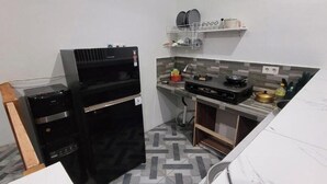 A compact kitchen with a built-in oven, a stove, and a sink. - Umah Yugadi Bali (Bali)