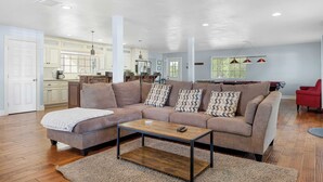 Ein geräumiges Wohnzimmer mit einer Couch, einem Couchtisch und einem Billardtisch.