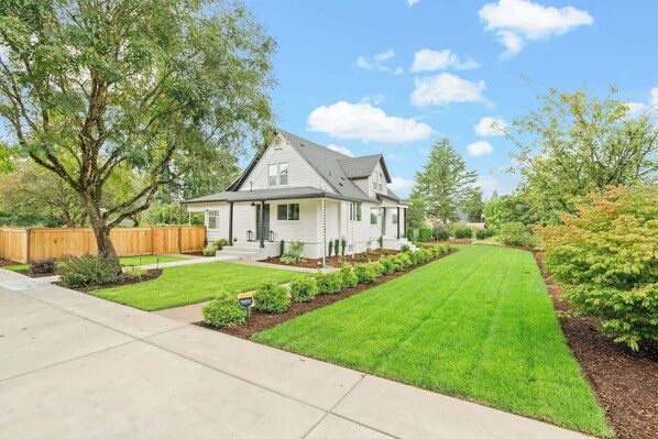 A single-story house with a front yard, a wooden fence, and a well-maintained lawn. - Contemporary Camas Retreat (Camas)