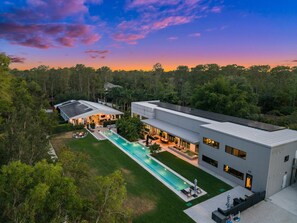 A modern house with a swimming pool, surrounded by trees. - 2.5-Acre Modern Industrial Estate Tennis, Gym, Pool, Pickle Ball, Hot Tub, Bocce (Naples)