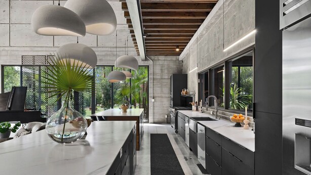 A modern kitchen with a central island, stainless steel appliances, and pendant lighting.