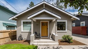 A single-story house with a front porch, a wooden door, and a mailbox.