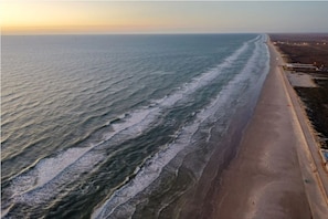 A coastal view with a sandy beach and ocean waves.
