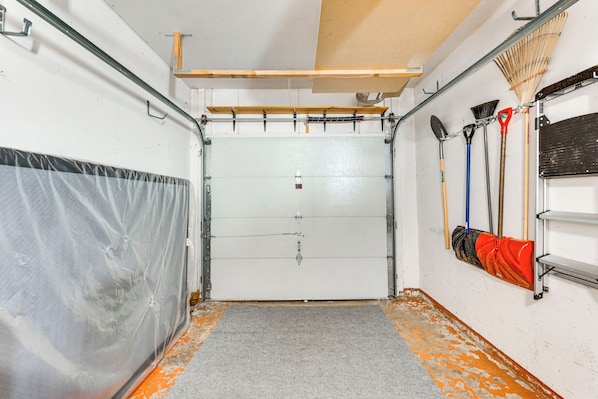 Ein Zimmer mit einer großen weißen Tür, einem grauen Teppich und einer Wand mit verschiedenen Reinigungsmitteln.