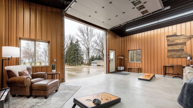 A spacious living area with a leather sofa, a coffee table, and a wooden floor. - Copper Lodge - Lake Miltona
License #:  1999 (Miltona)
