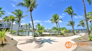 Zona turística con palmeras, piscina y pavimento en forma de estrella.