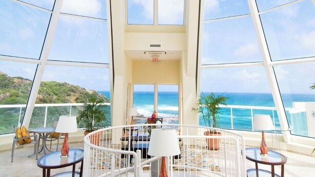 Un balcón amplio con vistas despejadas al océano y un paisaje tropical.