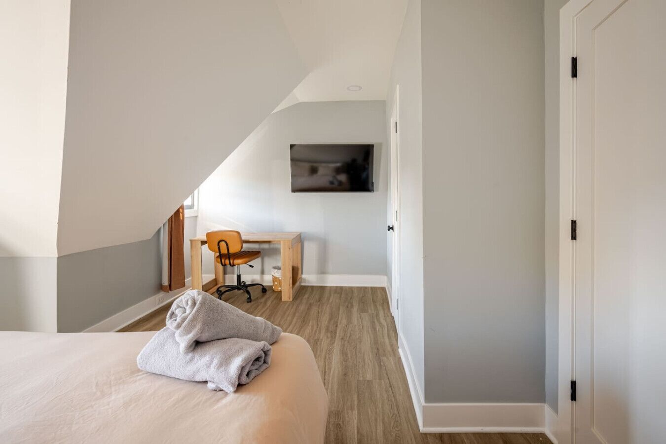 Un dormitorio con cama, escritorio y silla.