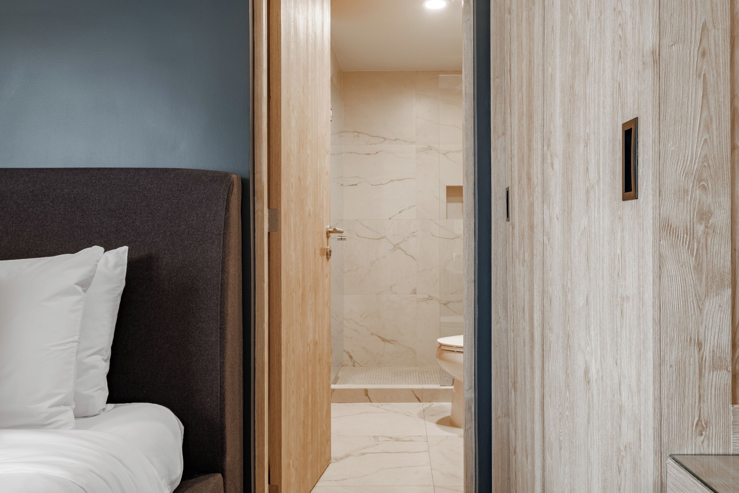 Une salle de bain moderne avec une douche en marbre, des toilettes et un espace douche.