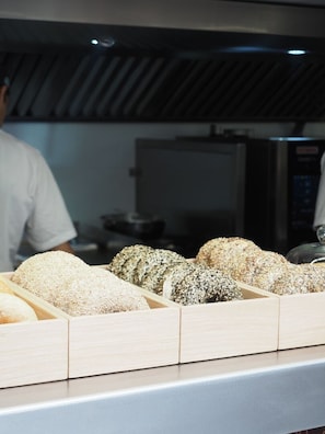 A bakery display with various types of bread. - District Polanco by Lumina (Mexico City)