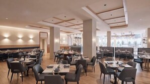 A spacious restaurant with multiple dining tables and chairs, a wooden floor, and a modern ceiling design. - HotelMOTEL Adelaide (Adelaide)