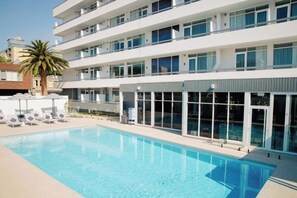 A modern hotel with a swimming pool, multiple floors, and a palm tree. - HotelMOTEL Adelaide (Adelaide)