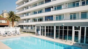 A modern hotel with a swimming pool, multiple floors, and large windows. - HotelMOTEL Adelaide (Adelaide)