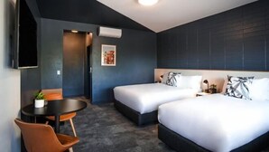 A hotel room with two beds, a desk, and a chair. - HotelMOTEL Adelaide (Adelaide)