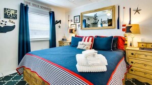 A neatly arranged bedroom with a bed, a nightstand, a dresser, and a ceiling fan.