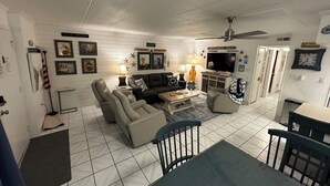 A living room with a sofa set, a coffee table, a TV, and a ceiling fan.