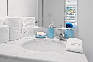 Een badkamer met een witte wastafel, een spiegel en toiletartikelen.