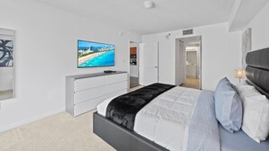 A modern bedroom with a bed, a TV on the wall, and a walk-in closet. - The Club 2020 Duplicate · Supber unit, centrally located with parking (Miami)