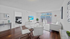A modern, well-lit living room with a dining area, a separate bedroom, and a balcony with a city view. - The Club 2020 Duplicate · Supber unit, centrally located with parking (Miami)