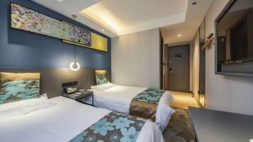 A hotel room with two beds, a desk, a chair, a large painting on the wall, and a mirror.