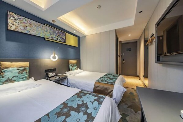 A hotel room with two beds, a desk, a chair, a large painting on the wall, and a mirror. - Yueyue Chain Hotel (Zhengzhou Dehua Pedestrian Street Erqi Square Subway Station) (Zhengzhou)