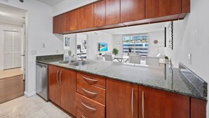 A modern kitchen with wooden cabinets, granite countertops, and stainless steel appliances.