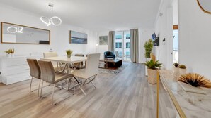 A modern living room with a dining area, large windows, and a view of the city. - The Club 1606 · Impressive Unit in the heart of Brickell W Parking (Miami)