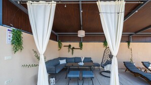 An outdoor patio with a sofa, table, and lounge chairs, featuring a wooden ceiling and hanging plants. - Amazing home in Jadreski with private swimming pool, can be inside or outside (Jadreski)