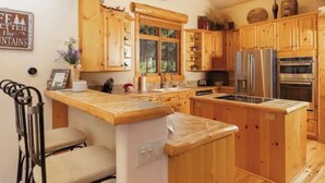 A kitchen with wooden cabinets, a stainless steel refrigerator, and a built-in oven. - Amazing Mountain Home in Blue River-7 minutes from Breckenridge! (Blue River)