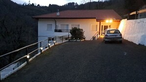 A building with a red-tiled roof, a car parked in front, and a gravel driveway leading to a gated entrance. - Fantástico Retiro Rural en el Corazón de Euskadi (Elgoibar)
