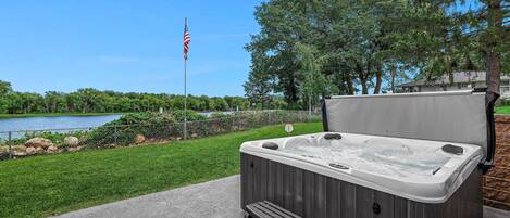 A hot tub with steps, a flag, and a view of a lake.