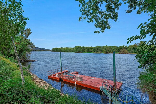 Un bateau rouge était amarré sur un lac paisible, entouré de verdure.