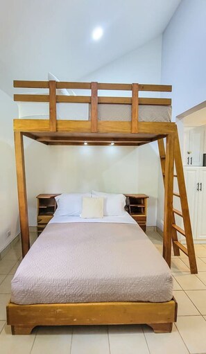 Een stapelbed met houten frame, een enkel bed beneden en een ladder aan de rechterkant.