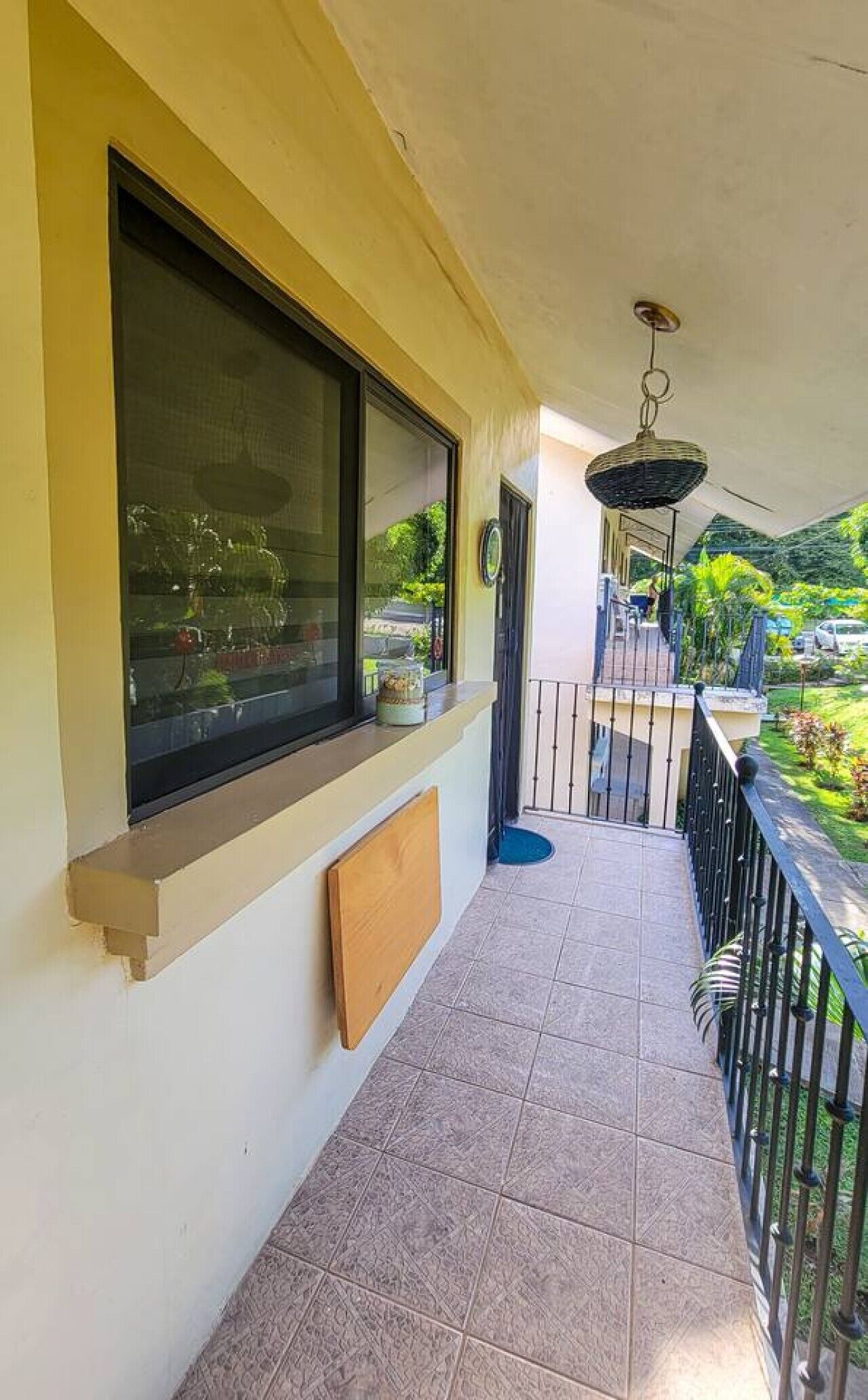 Un balcon fermé doté d’une fenêtre, d’une porte et d’un luminaire suspendu.