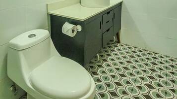 Ein Badezimmer mit Toilette, Waschbecken und Spiegel.