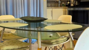 A round glass table with a central bowl, surrounded by cushioned chairs. - Villa Riviera Walk to Beach Condo Playas del Coco (Del Coco Beach)