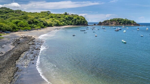 A coastal beach with boats, clear water, and lush greenery. - Lovely Studio in Playa Ocotal (Playa Ocotal)