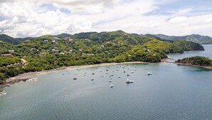 A coastal area with boats, a beach, and a forested hill. - Lovely Studio in Playa Ocotal (Playa Ocotal)