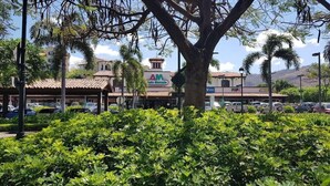 A building with a sign that reads 'AM' and a parking lot with cars. - Lovely 2 bdrm Condo in Pacifico (Coco)