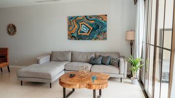 A modern living room with a sectional sofa, a wooden coffee table, and a large abstract painting.