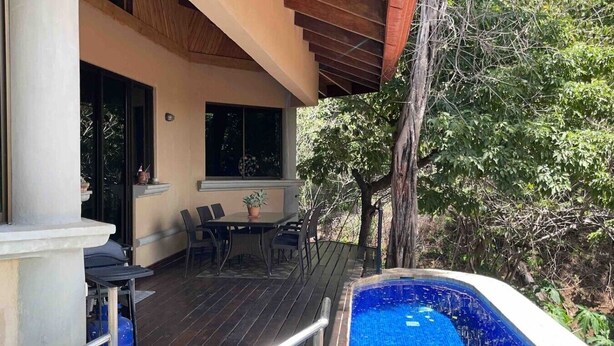 A covered outdoor area with a pool, a dining table with chairs, and a potted plant. - Ocean view and Private Pool in Playa Hermosa (Playa Hermosa)