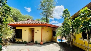 A yellow building with a red-tiled roof, a small porch, and a pool area. - Ocean view and Private Pool in Playa Hermosa (Playa Hermosa)