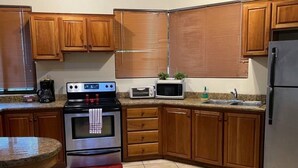 A kitchen with wooden cabinets, a stainless steel stove, a microwave, and a refrigerator. - Ocean view and Private Pool in Playa Hermosa (Playa Hermosa)