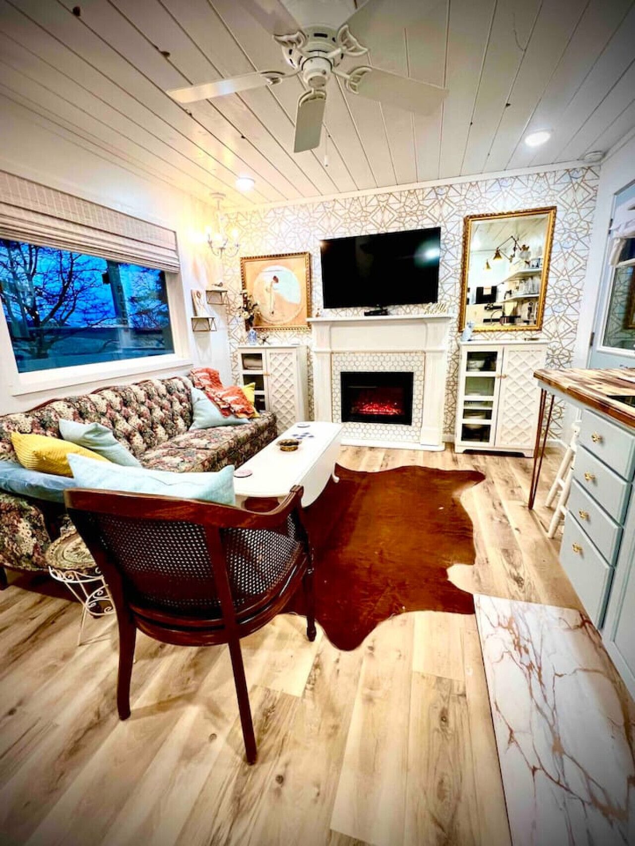 Ein gemütliches Wohnzimmer mit Kamin, Fernseher und einem Essbereich mit Holztisch und Stühlen.