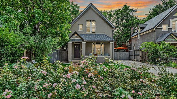 A residential house with a front porch, a covered patio, and a garden with pink flowers. - Cozy Victorian | King Bed, Private Yard, Walk to SoBo Restaurants (Denver)